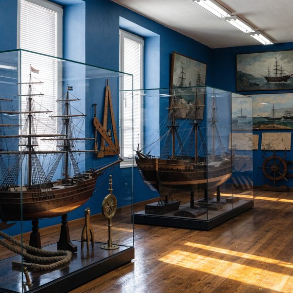 Salle des maquettes de navires en vitrine, parquet et murs bleus